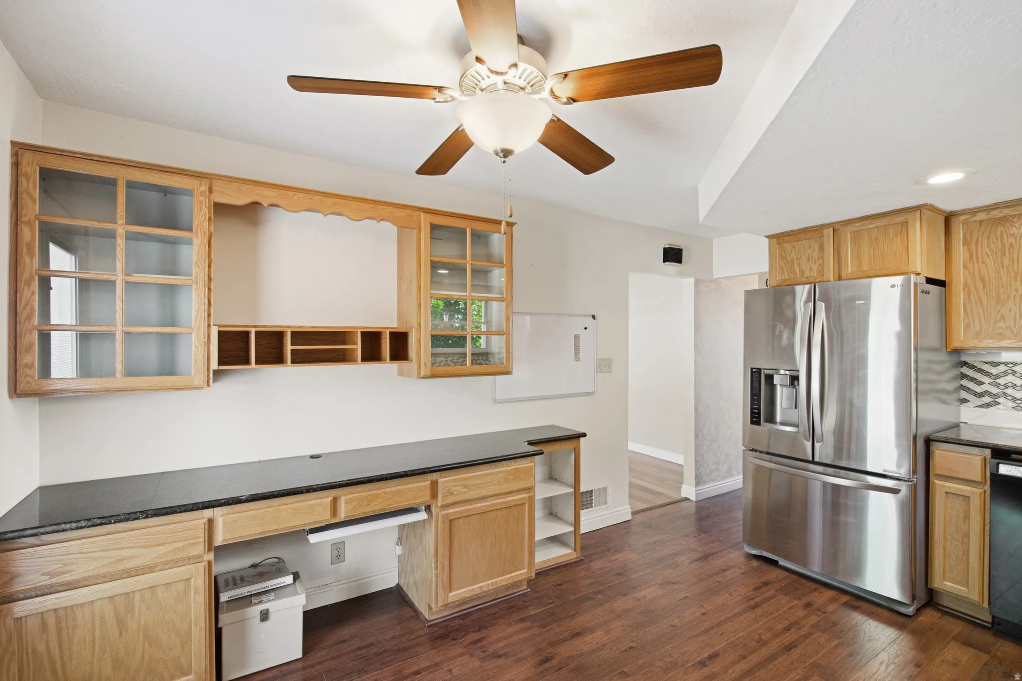 Built-in wood cabinetry with glass-paneled upper units and a recessed workstation