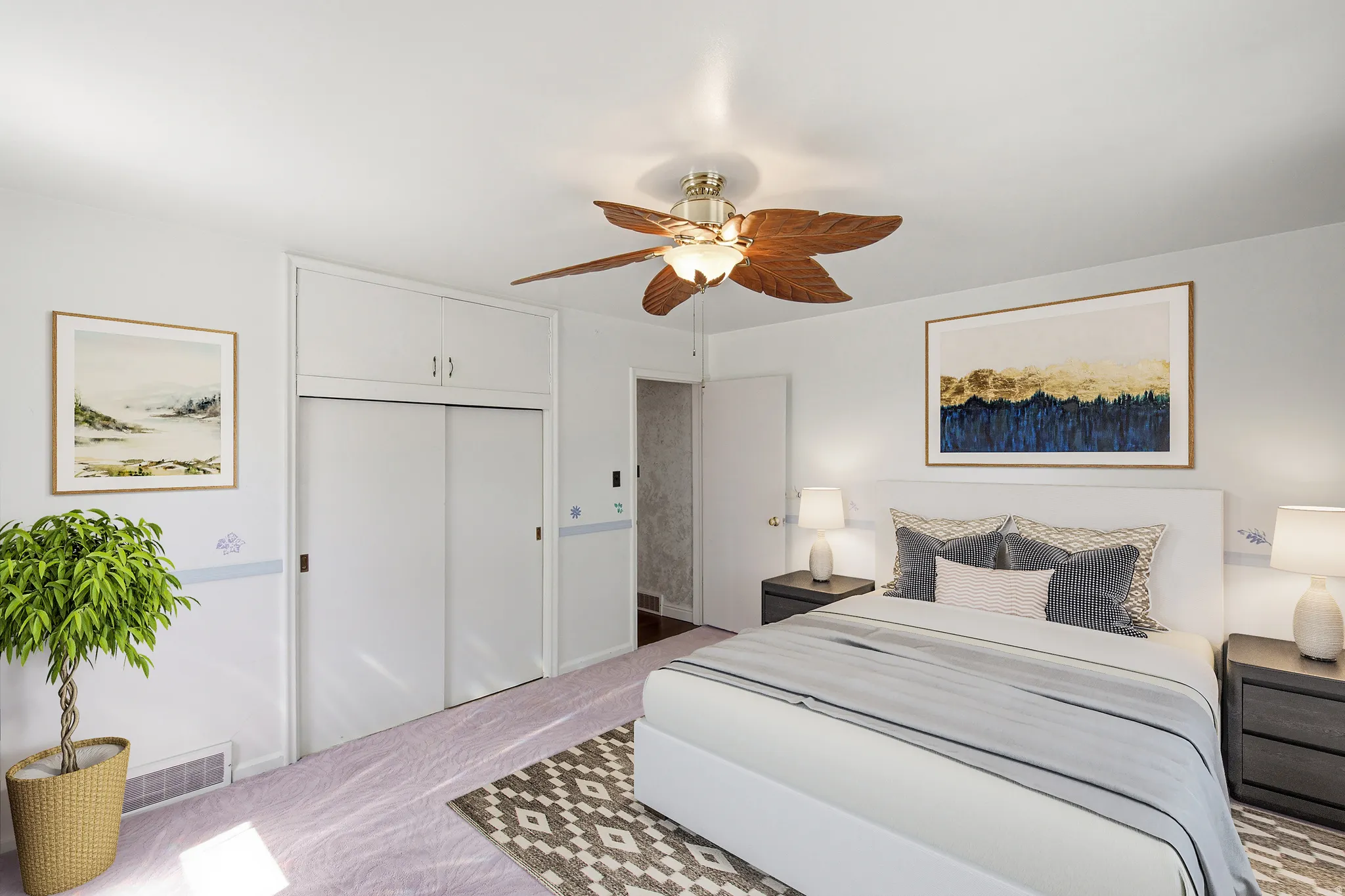 Bedroom featuring a ceiling fan, light-colored carpeting, built-in closet with sliding doors, and overhead cabinetry