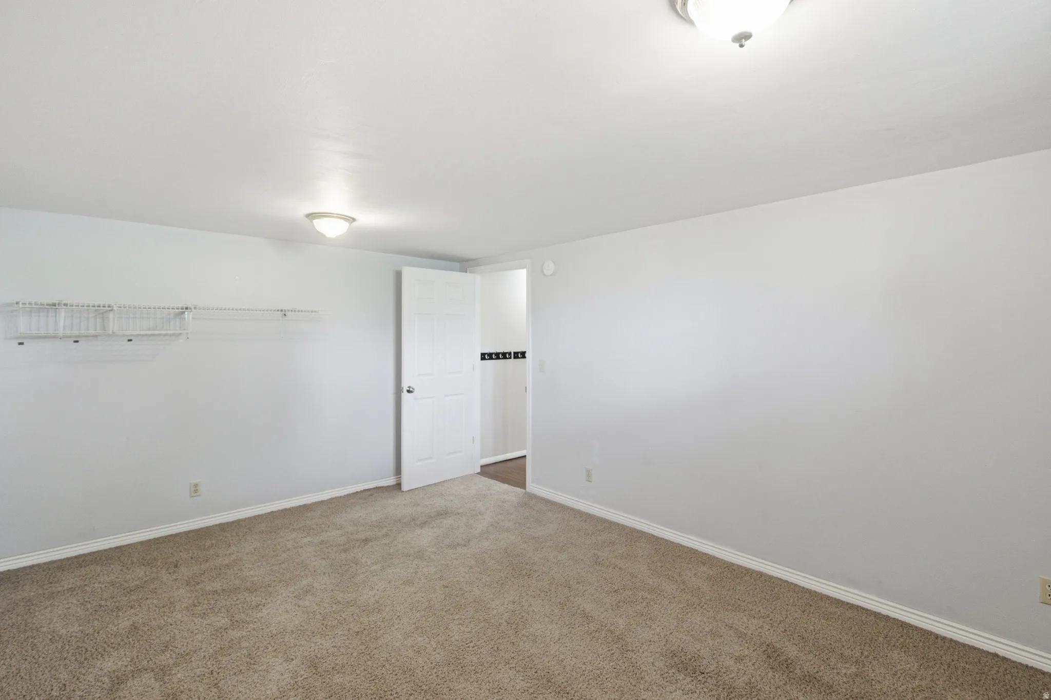Carpeted room featuring light gray walls, white baseboards, and a semi-flush ceiling light fixture