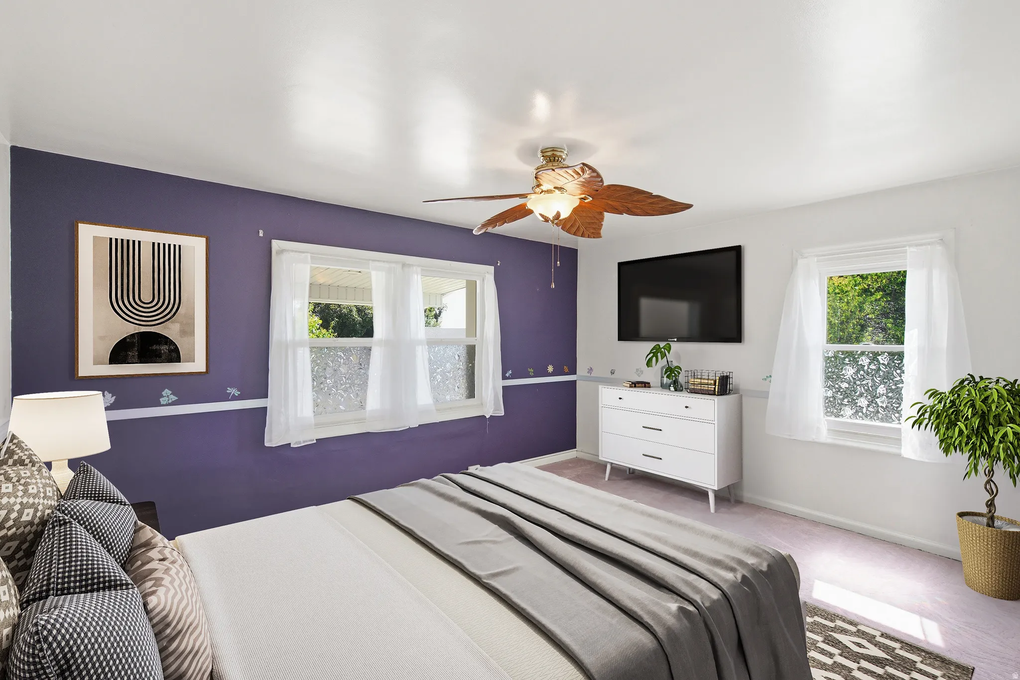 Bright interior space featuring a ceiling fan with integrated lighting, two windows with white trim, and a wall-mounted television