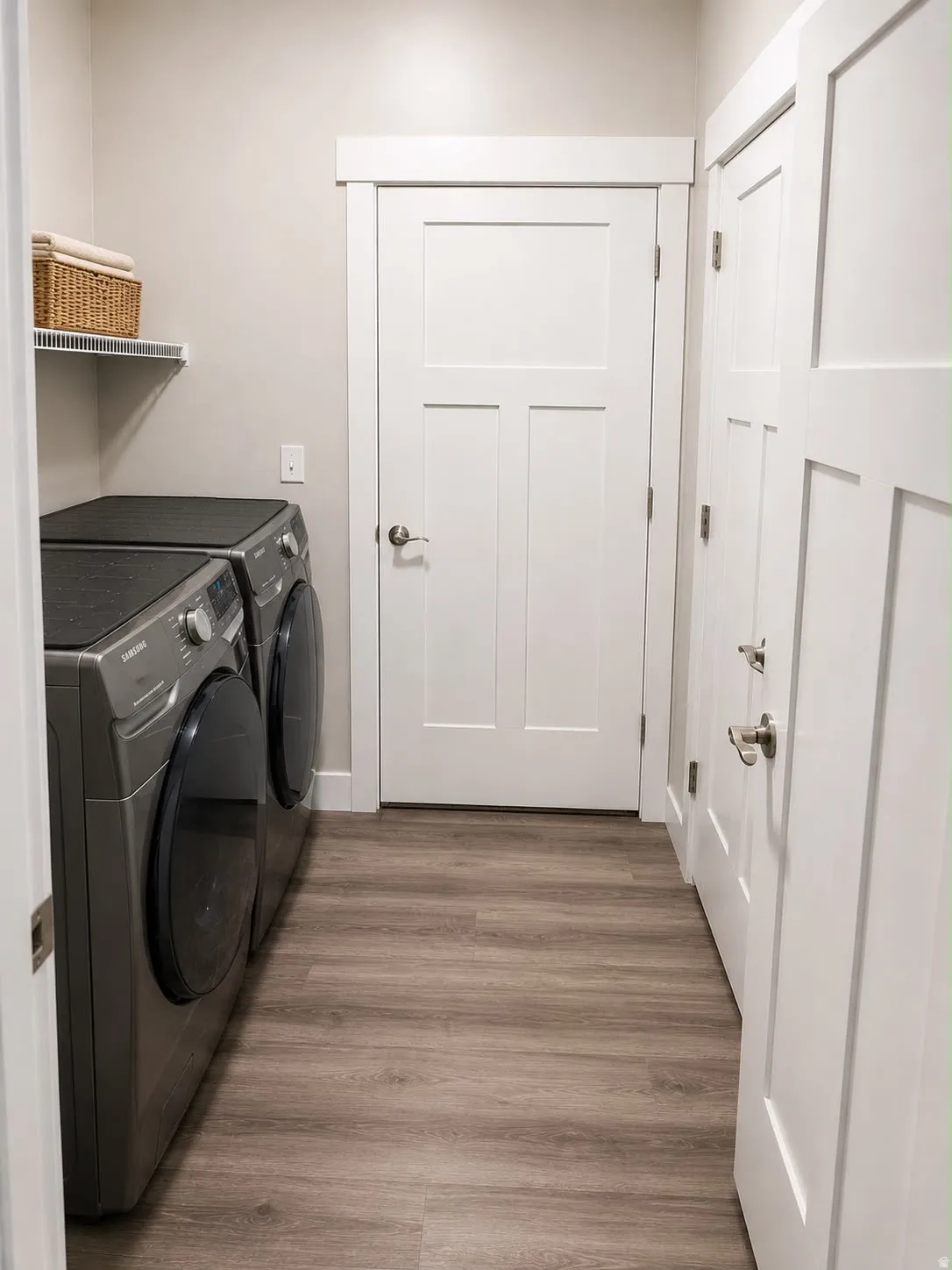 Dedicated laundry area featuring wood-finish flooring and neutral wall tones