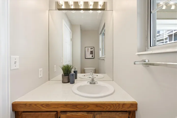 Bathroom vanity featuring a tiled countertop with an integrated sink and a chrome-finish faucet