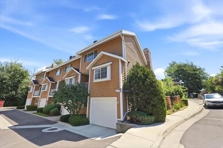 Multi-level townhome featuring siding exterior, white trim accents, and an attached garage