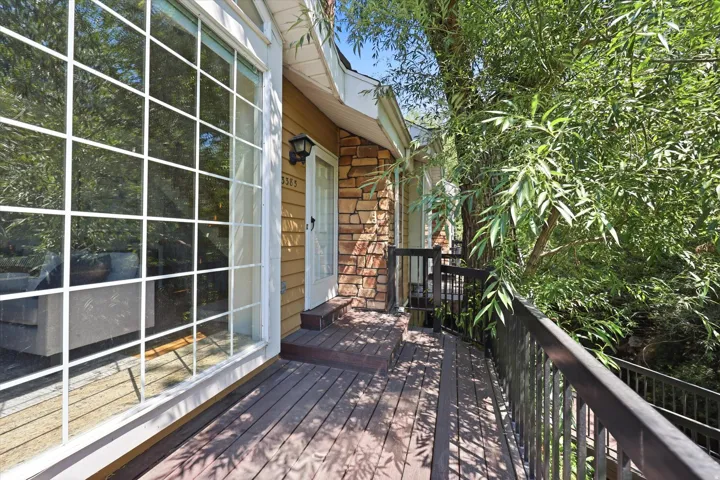 Exterior featuring wood-finish siding, stone accents, and a large grid-pattern window