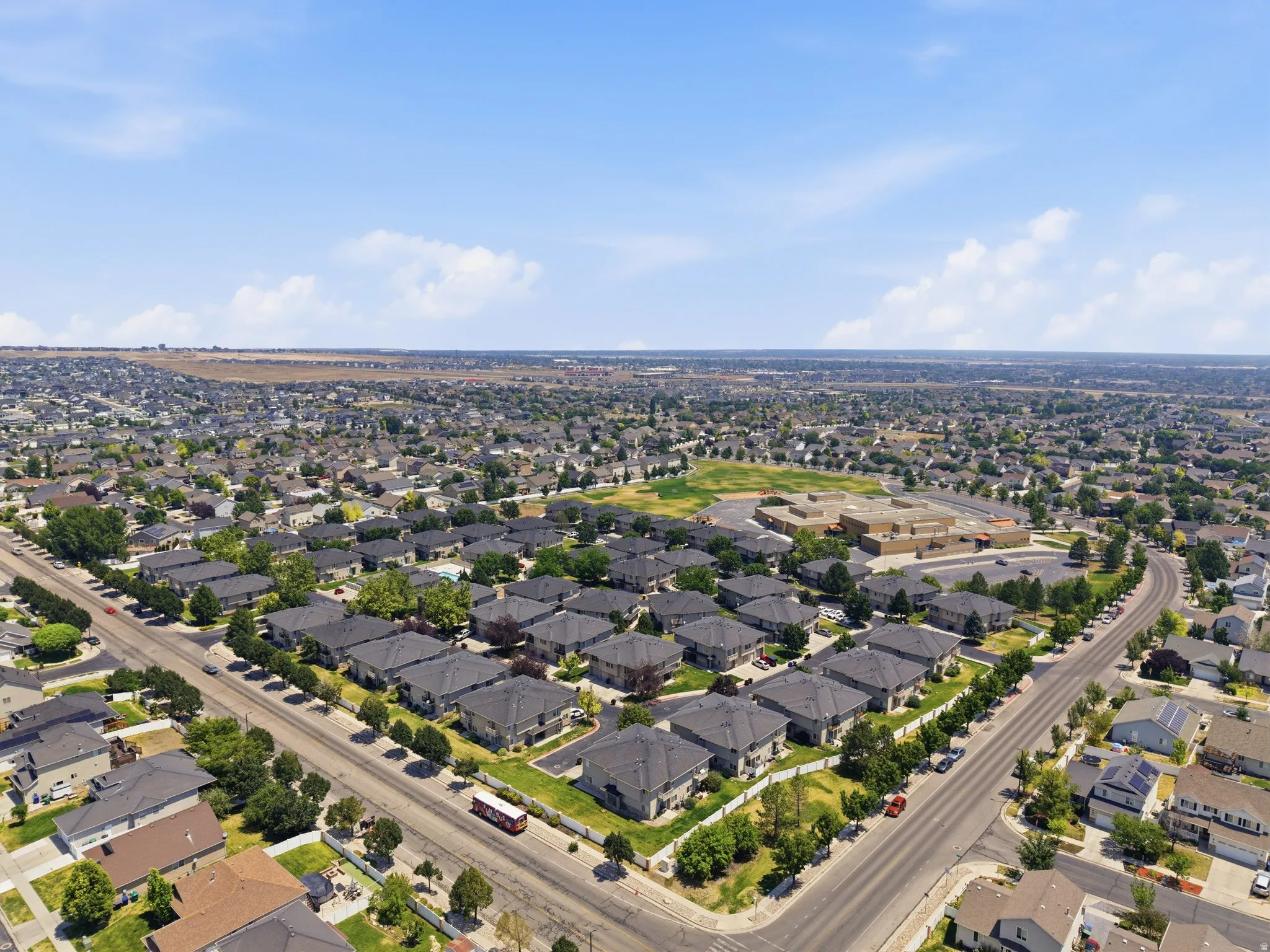 Aerial perspective showcasing a residential neighborhood with numerous single-family homes and dark-toned roofs