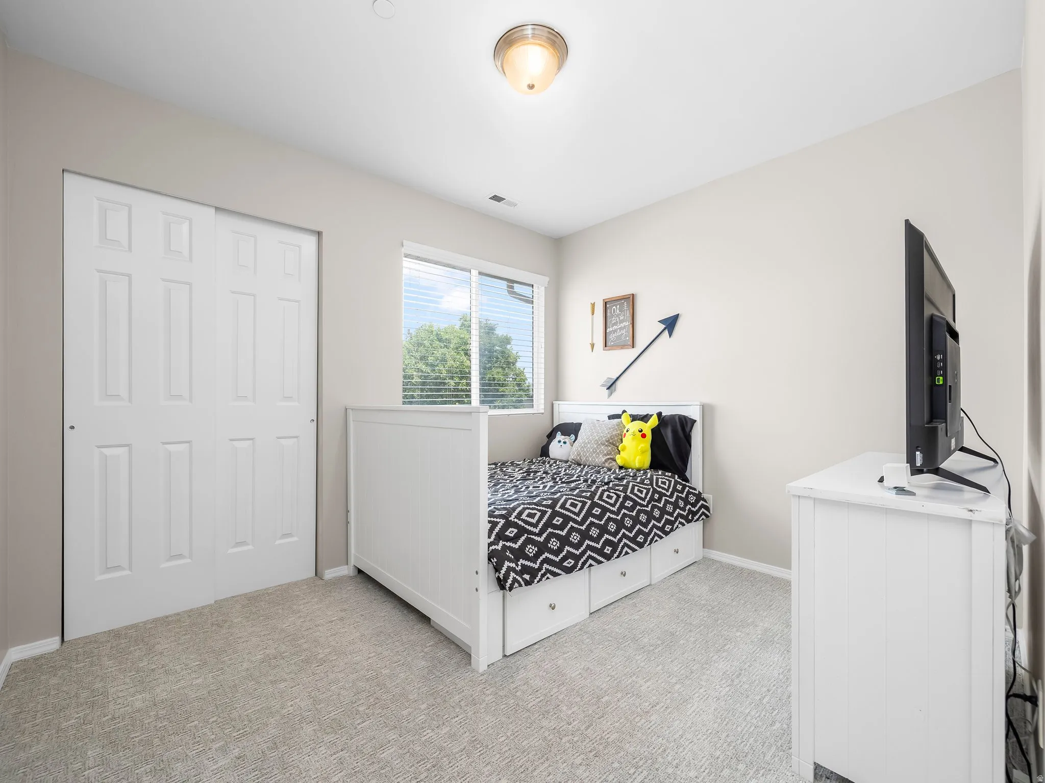 Neutral-toned room featuring light gray carpeting, a window with horizontal blinds, and a semi-flush mount ceiling light fixture