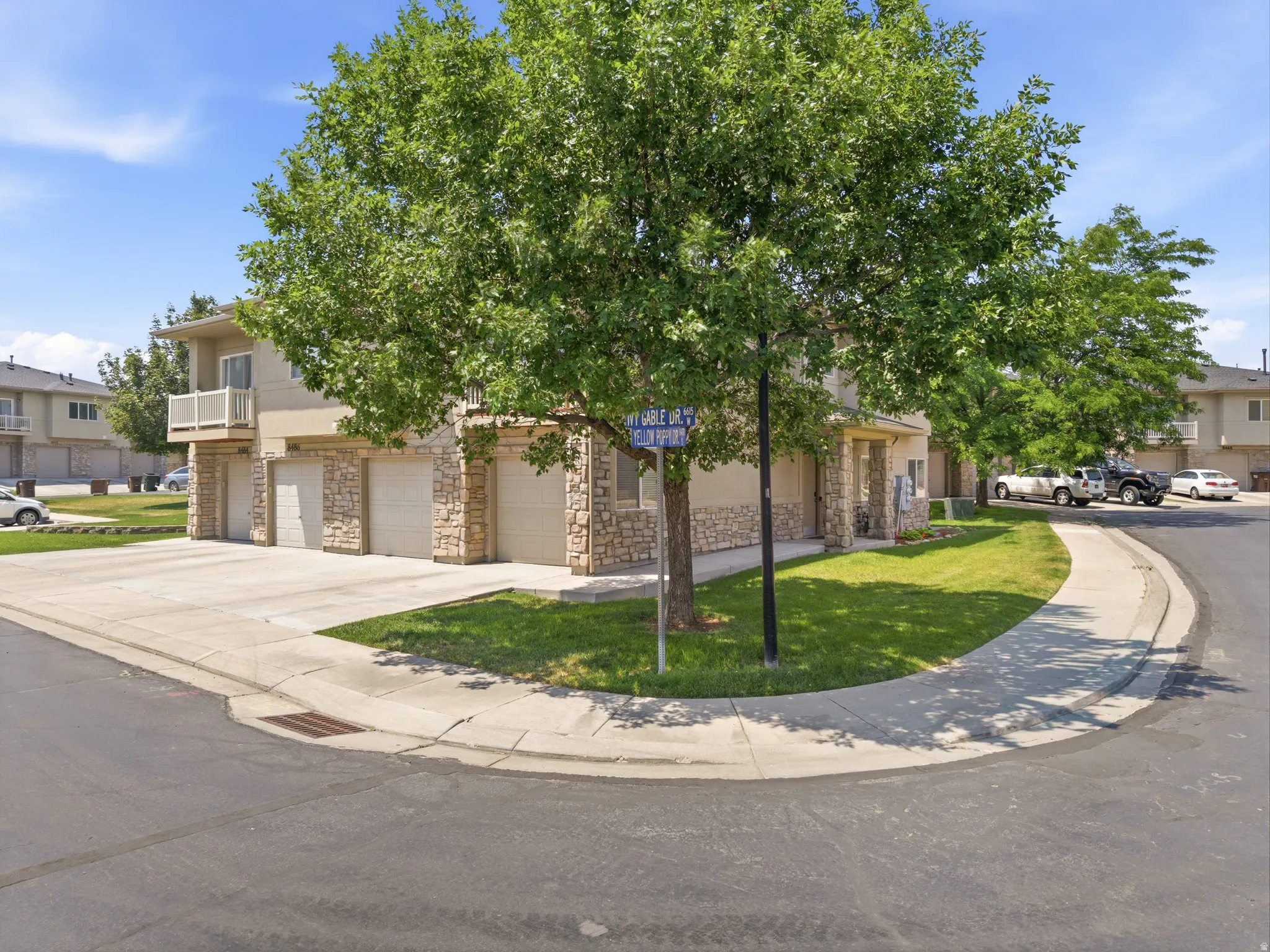 Townhome exterior featuring stone veneer accents and attached garages