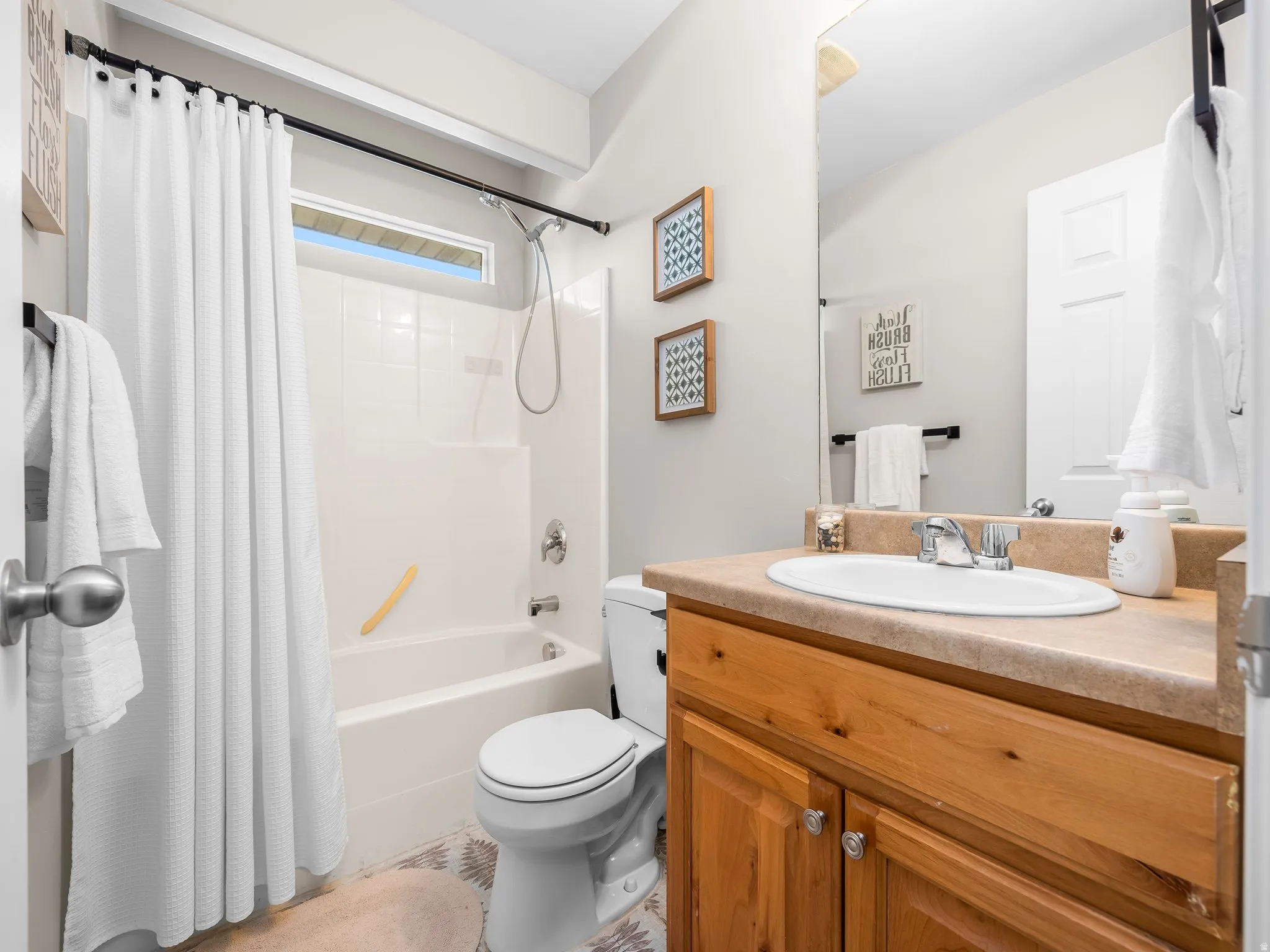 Bathroom featuring a single vanity with wood cabinetry, a neutral countertop, and an integrated sink