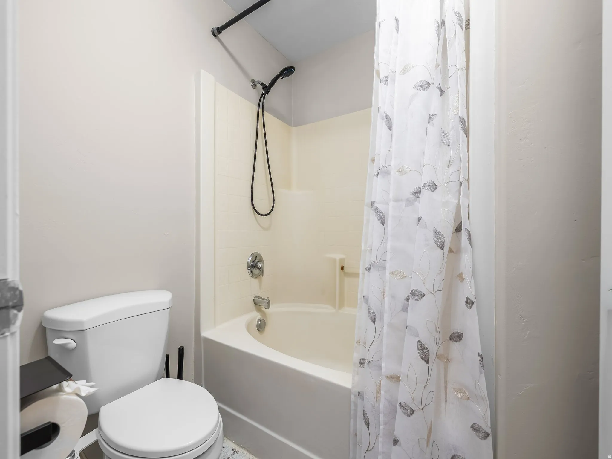 Bathroom featuring a tub/shower combination with a black matte showerhead, chrome fixtures, and a white toilet