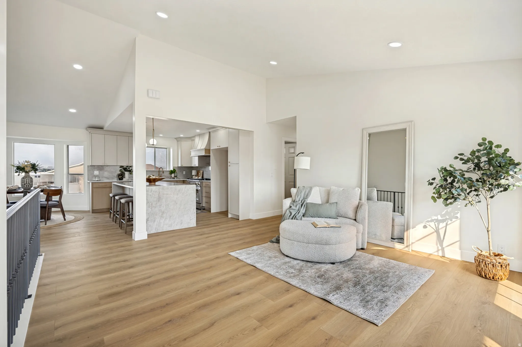 Open-concept living space featuring wood-finish flooring, recessed lighting, and a vaulted ceiling