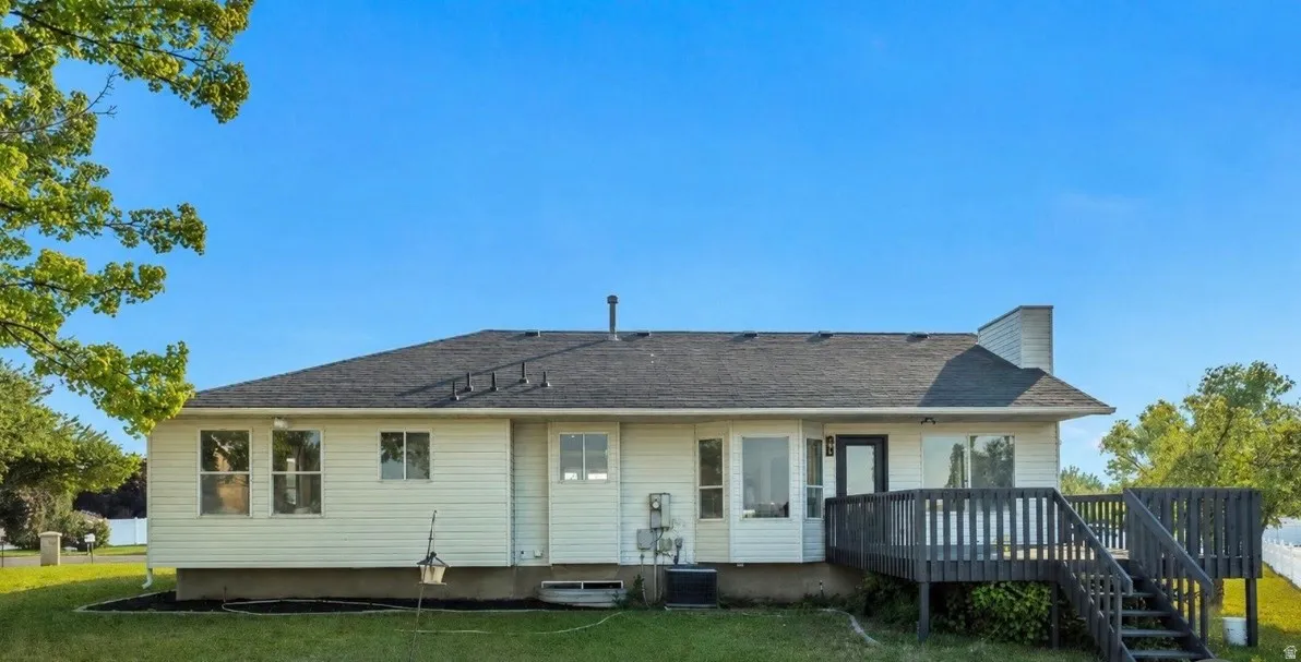Rear elevation with white horizontal siding and a dark shingle roof