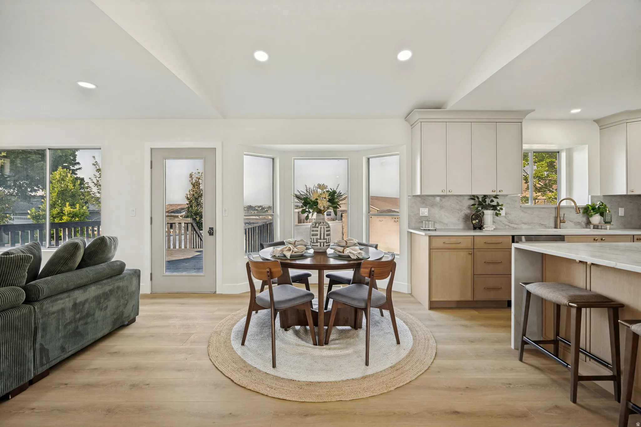 Open-concept living space featuring wood-finish flooring, recessed lighting, and a vaulted ceiling
