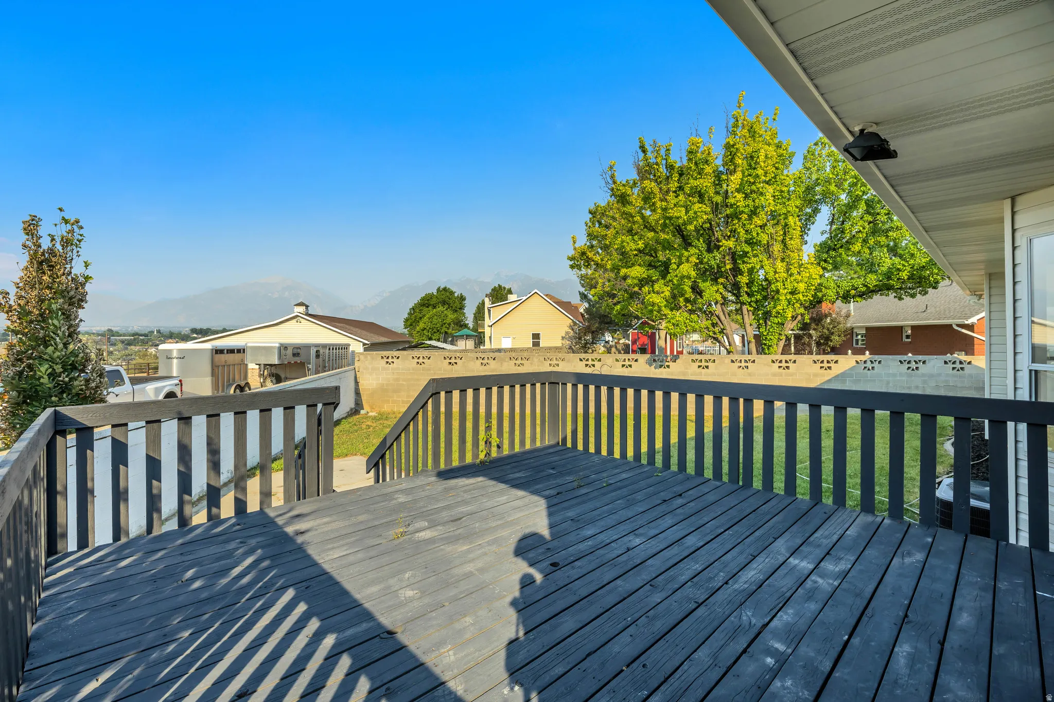 Expansive exterior deck featuring dark-stained wood planks and railings