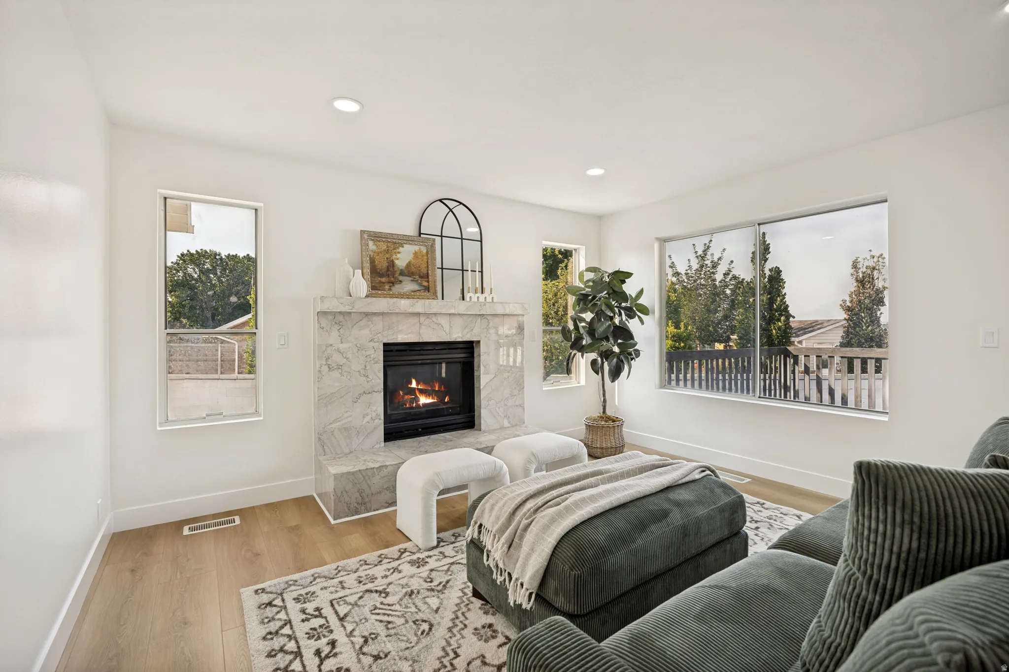Living area featuring a stone-clad fireplace and wood-finish flooring
