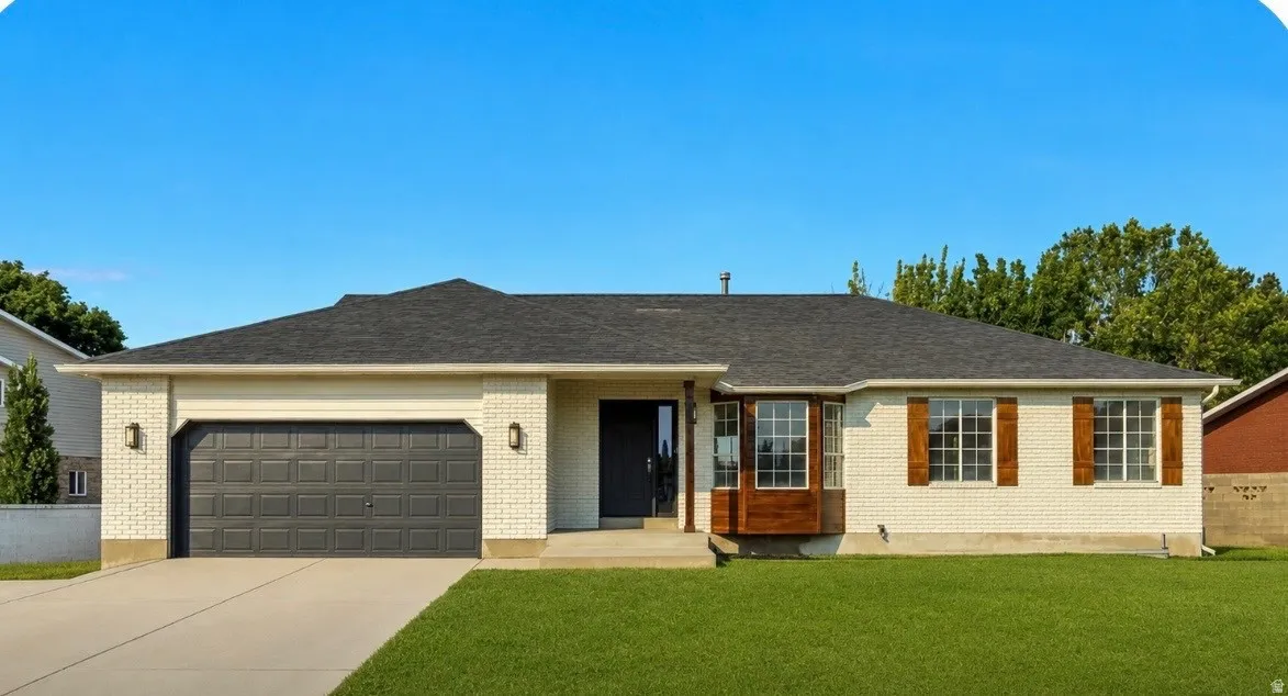 White brick exterior with a dark shingle roof