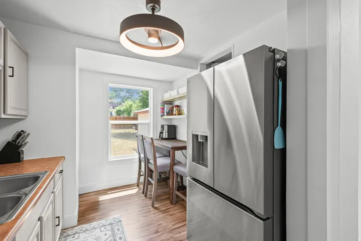 Bright kitchen area featuring a stainless steel French door refrigerator with a water dispenser