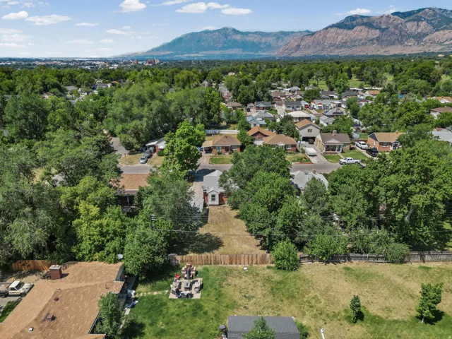 Suburban neighborhood with mature trees and a distant mountain backdrop