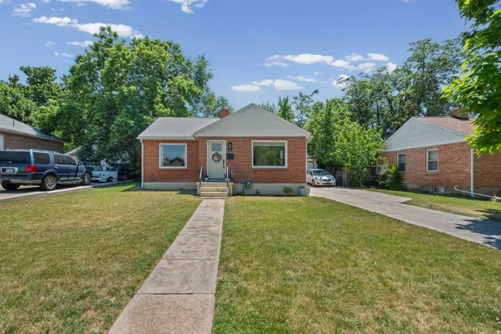 Brick residence with a prominent front lawn and mature trees