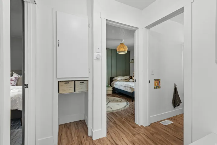 Hallway featuring wood-finish flooring and white baseboards