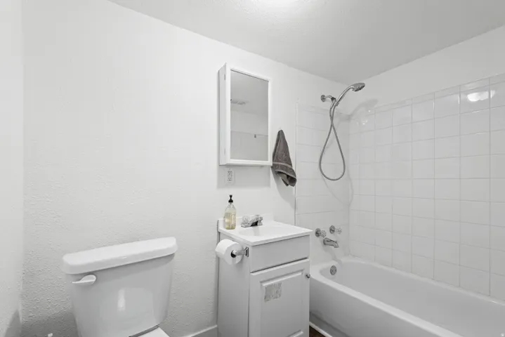Bathroom featuring a white vanity with integrated sink, chrome faucet, and a wall-mounted medicine cabinet