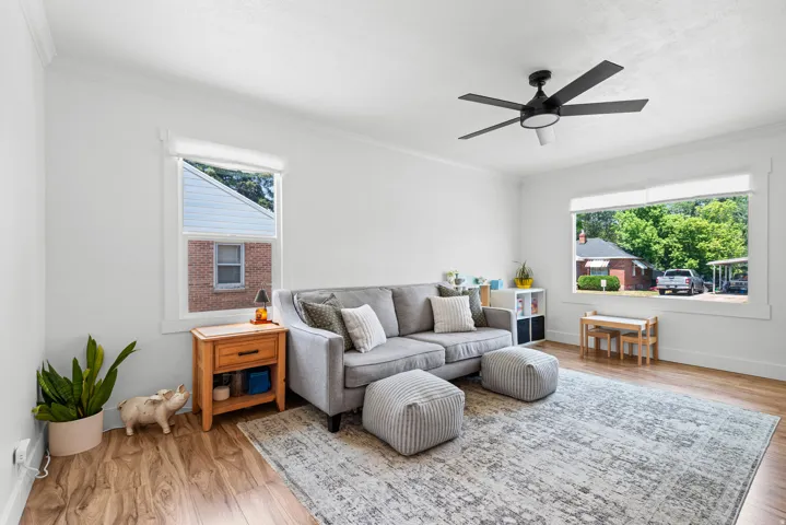 Spacious room featuring wood-finish flooring, white walls, and bright natural light from multiple windows