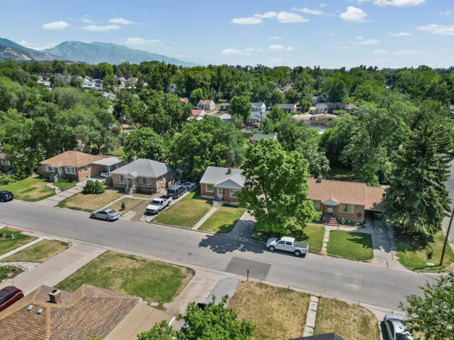 Residential streetscape featuring single-story homes with brick exteriors and various roof styles