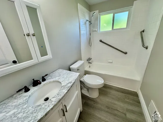 Bathroom with a white vanity featuring a marble-patterned countertop and undermount sink, bronze-finish faucet, and coordinating hardware
