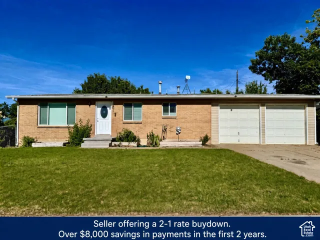 Brick exterior, two-car garage, concrete driveway, and front lawn