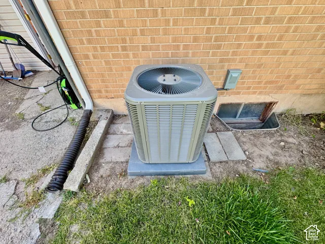 Outdoor HVAC unit on a concrete pad against a brick exterior