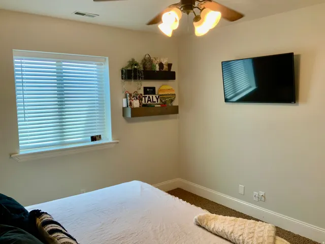 Neutral-toned walls complement the carpeted flooring and white trim
