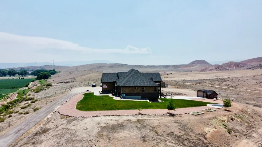Expansive property featuring a multi-level residence with a dark shingle roof, wood siding, and a stone-clad lower level
