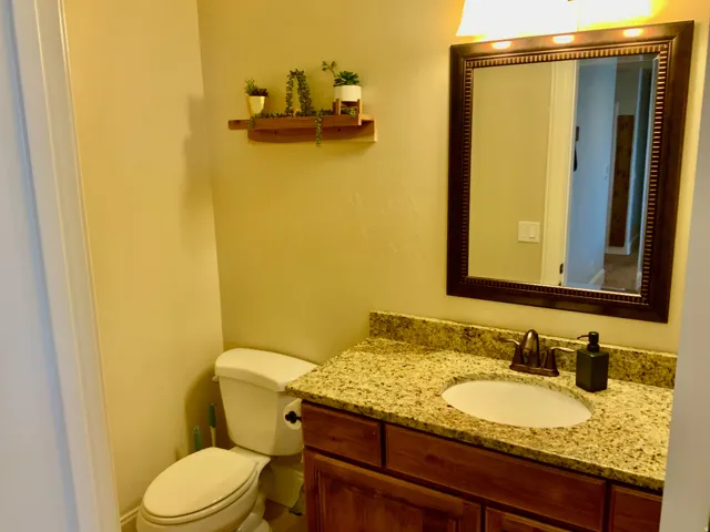Bathroom vanity featuring a granite countertop, undermount sink, and a dark wood-finish cabinet