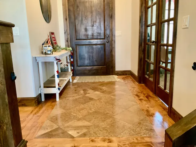 Entryway featuring wood-finish flooring with a central patterned tile inlay