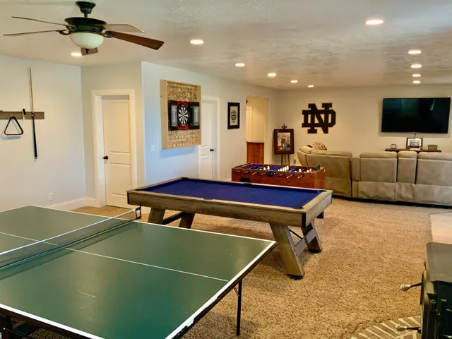Spacious recreation area featuring recessed lighting, a ceiling fan, plush carpet flooring, light-colored walls, and white interior doors