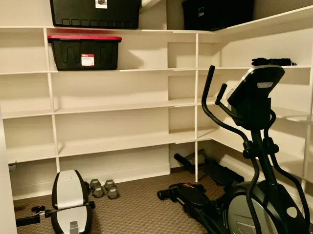Built-in white shelving system with a brown carpeted floor