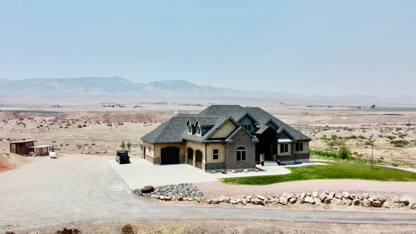 Stone and stucco exterior with multiple gables and a dark shingle roof