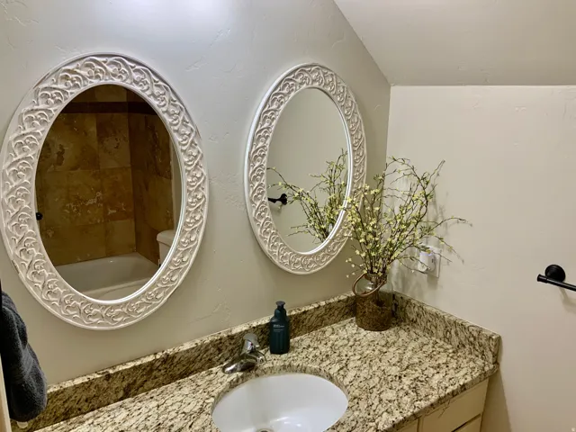 Dual oval mirrors with ornate white frames