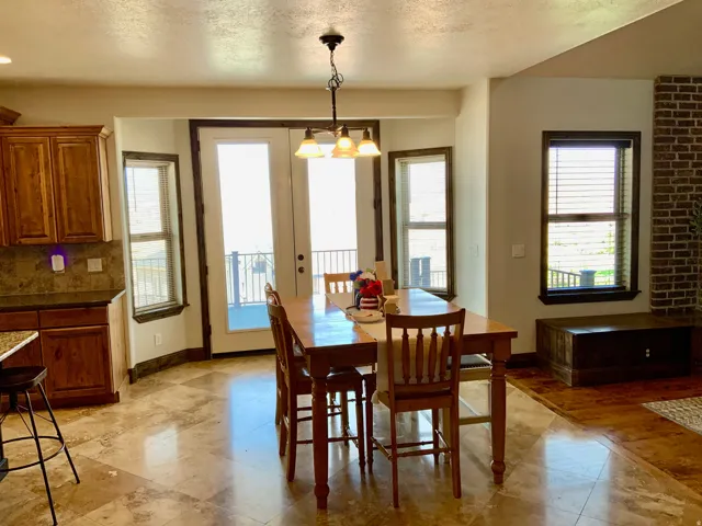 Dining area featuring a tile floor, a chandelier, and double French doors opening to an outdoor space