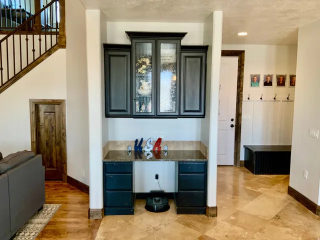 Built-in office nook featuring dark cabinetry and a granite-style countertop