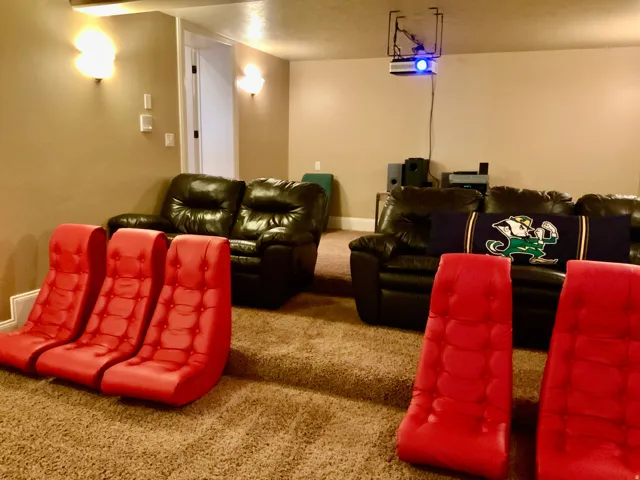 Dedicated media room featuring tiered carpeted flooring