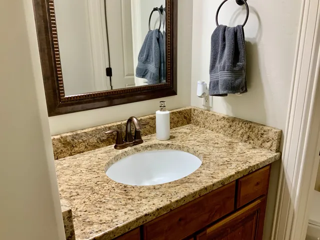 Vanity featuring a stone-look countertop, integrated oval sink, and bronze-finish faucet