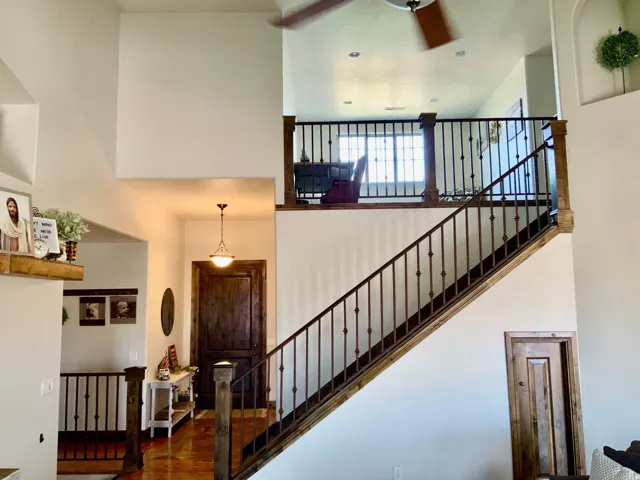 Staircase featuring dark wood handrails and wrought iron balusters