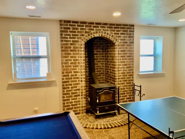 Brick-clad fireplace with arched opening and wood-burning stove
