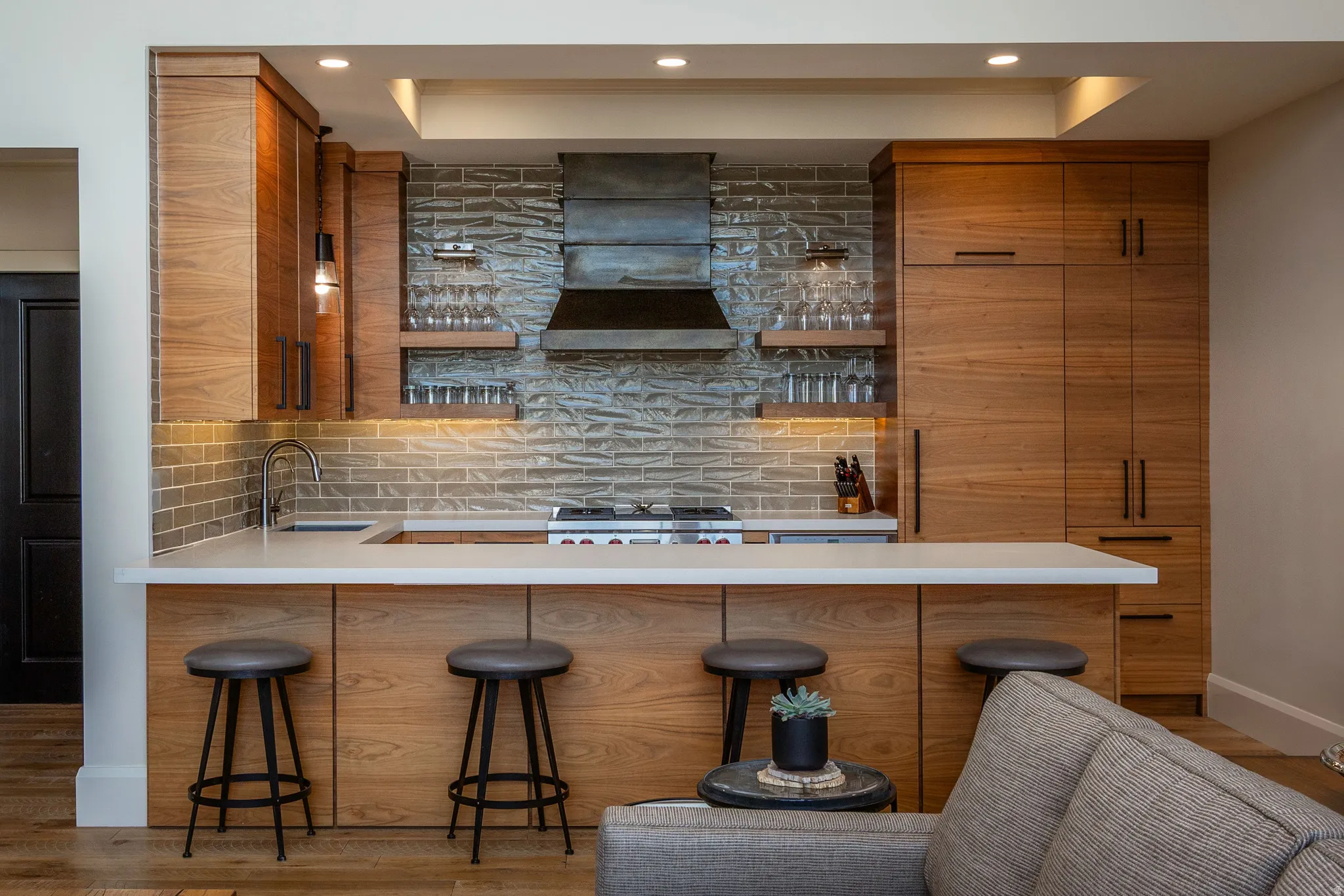 Kitchen featuring wood-finish cabinetry, white countertops, and a textured subway tile backsplash