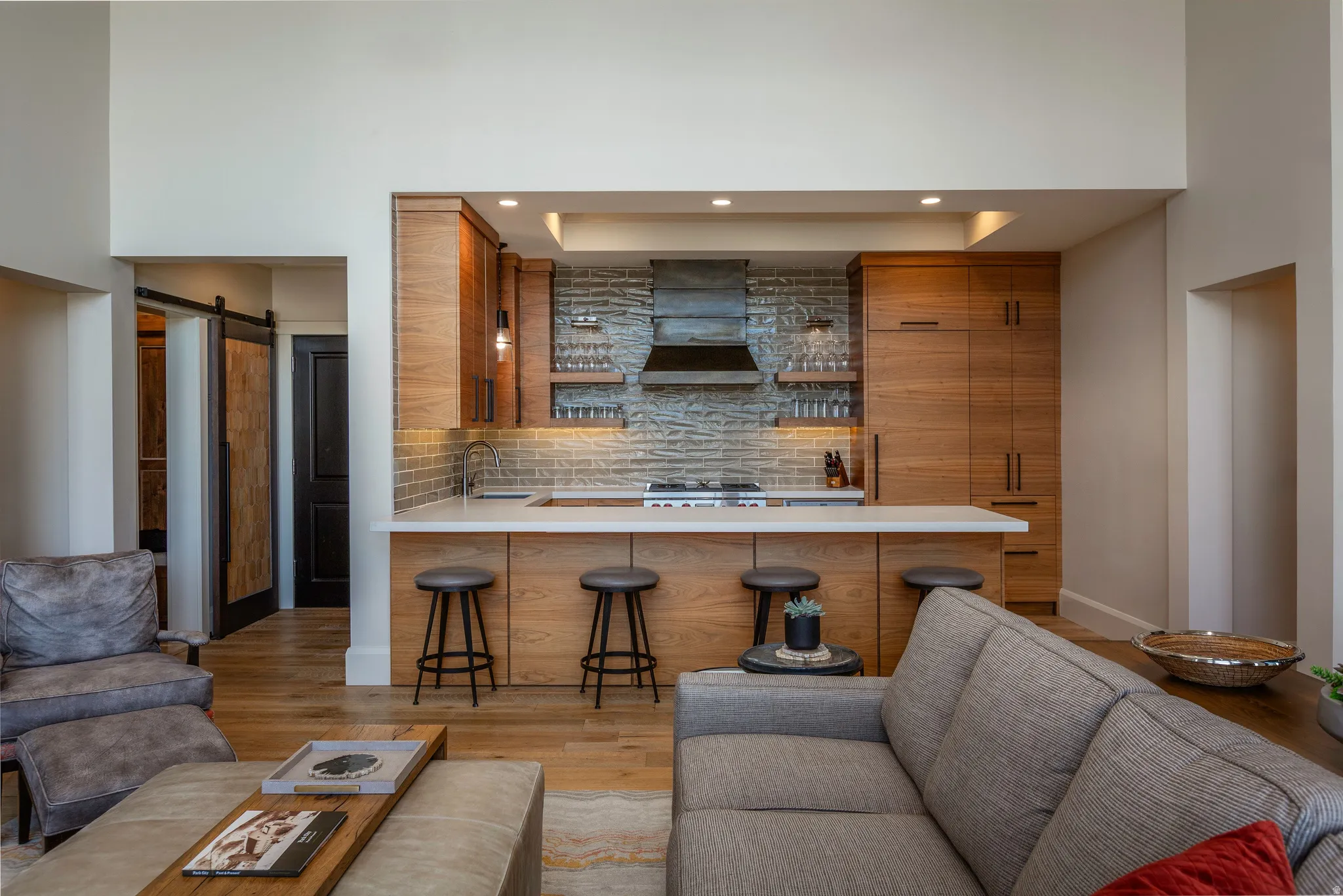 Kitchen island with seating, integrated cooktop, and stone backsplash