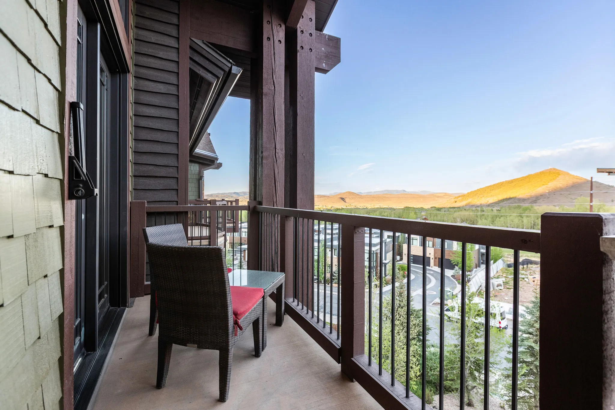Private balcony featuring wood-shingle siding, robust timber framing, metal railing, and a durable concrete surface
