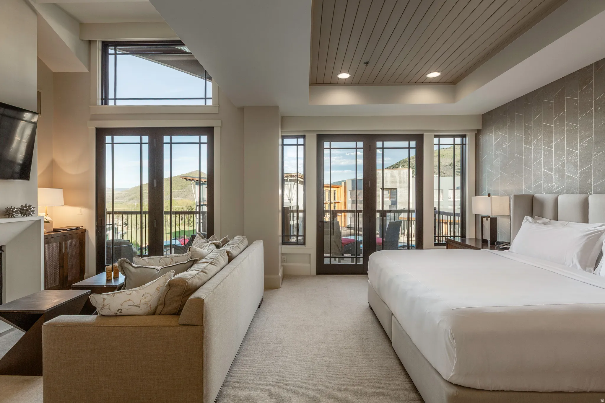 Spacious interior featuring a large picture window, French doors, and a private balcony