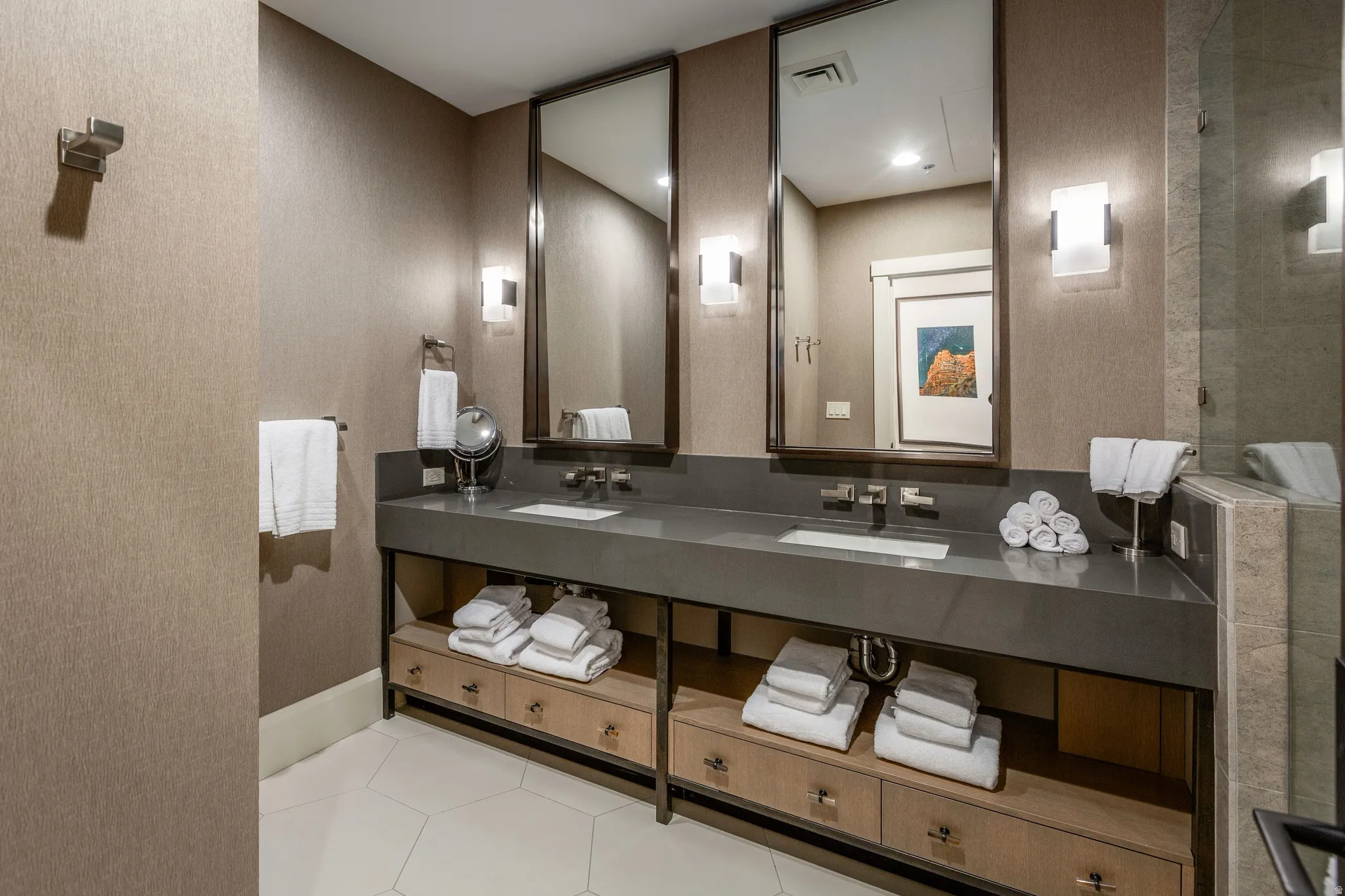 Dual vanity with an integrated rectangular sink, dark countertop, and two framed mirrors