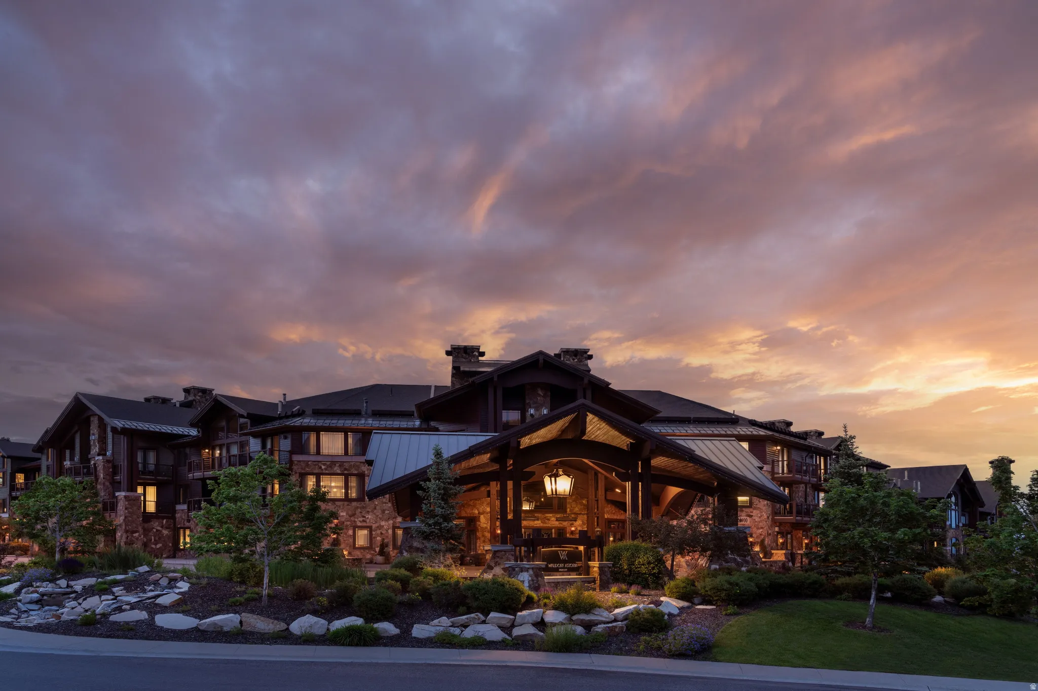 Expansive lodge-style building featuring a stone and wood exterior with multiple balconies