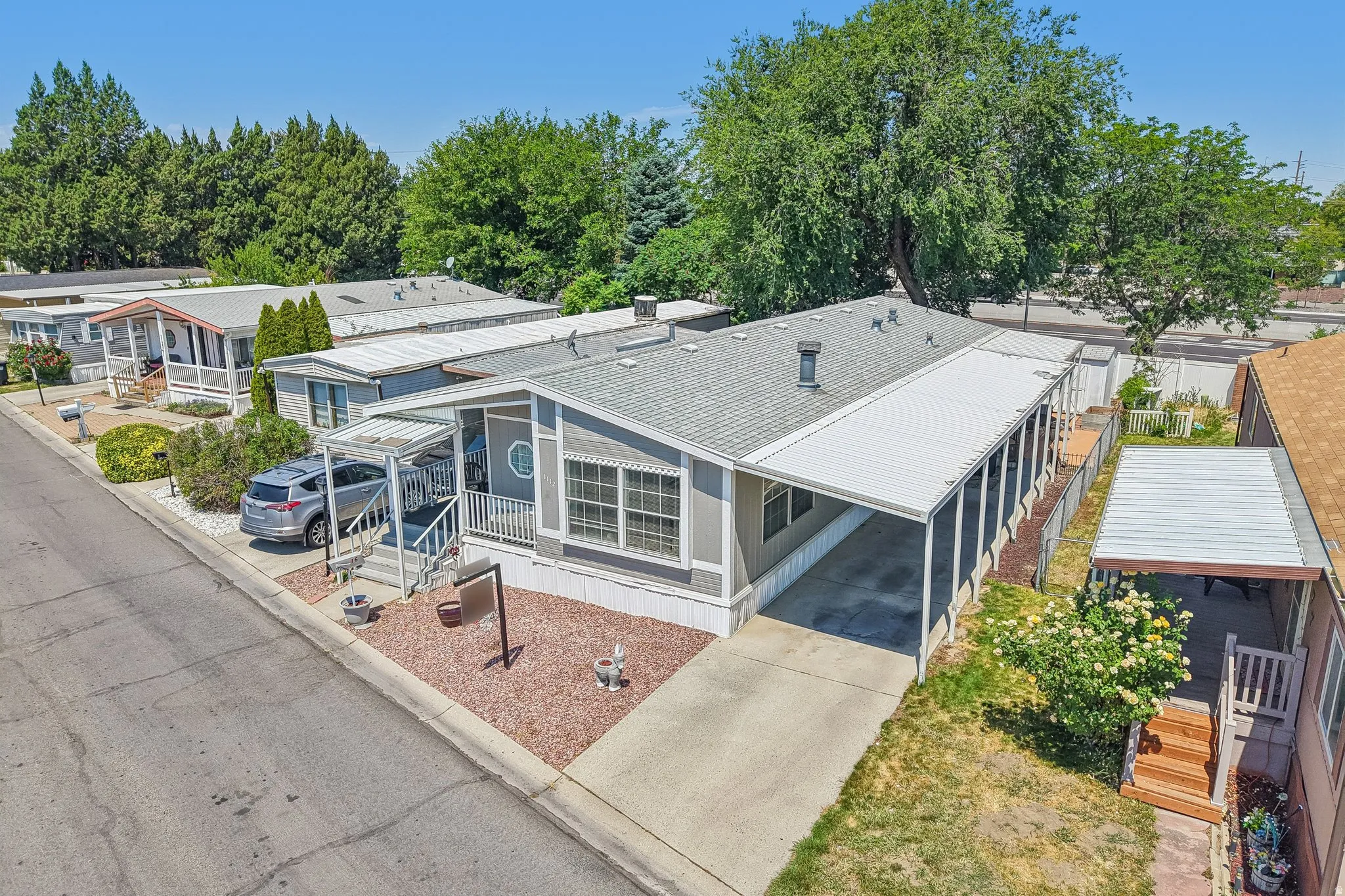 Single-story residence featuring gray siding and a covered carport